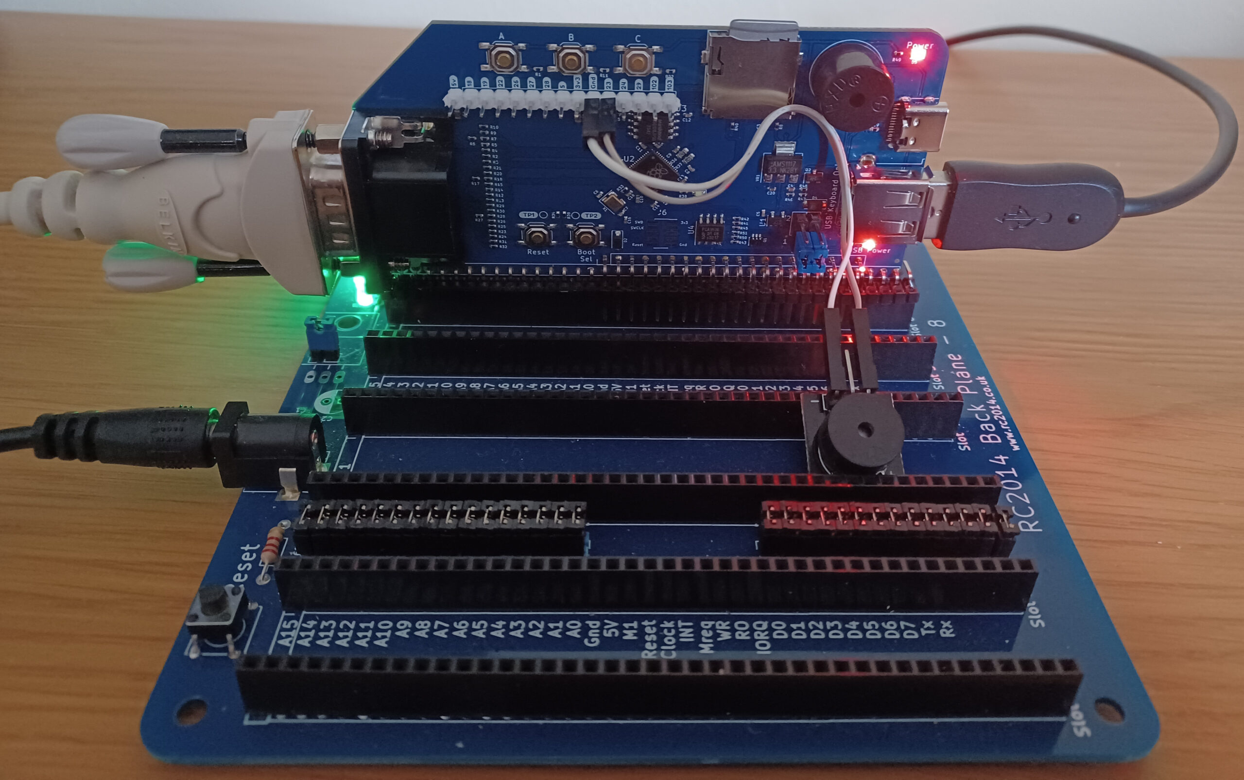 A RC2014 backplane 8 holding a RP2040 VGA terminal card. There's a passive buzzer attached to gpio 23 via the expansion header. The card is running the Pico MZ-80K emulator.