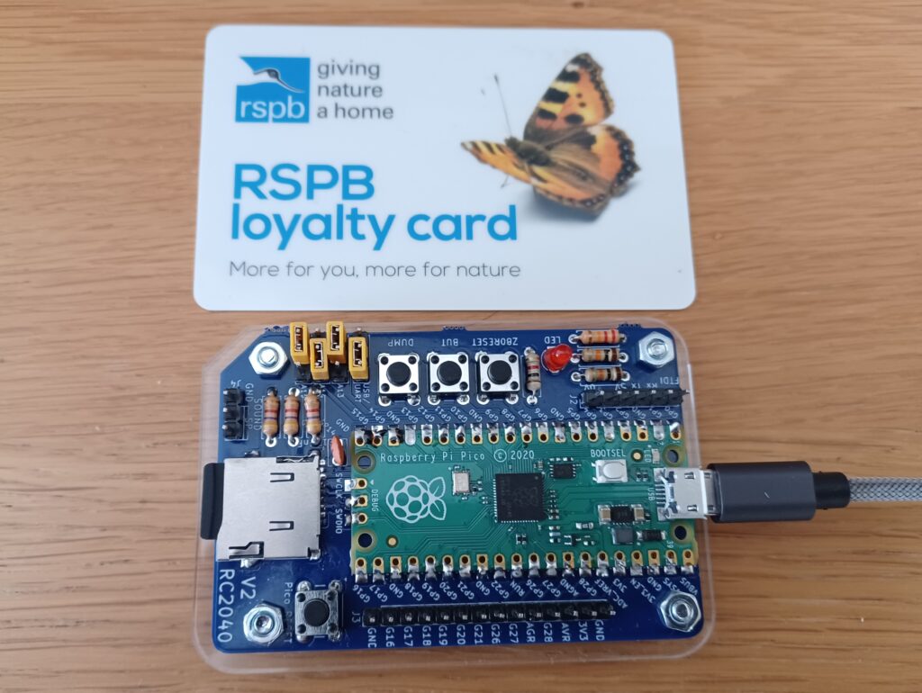 Photograph of am RC2040 computer below a credit-card sized loyalty card for scale. The RC2024 is slightly smaller than a credit card.